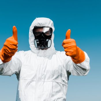 exterminator-in-protective-mask-and-uniform-standing-and-showing-thumbs-up.jpg