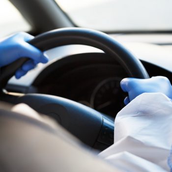 unrecognizable-person-in-hazmat-driving-a-car.jpg